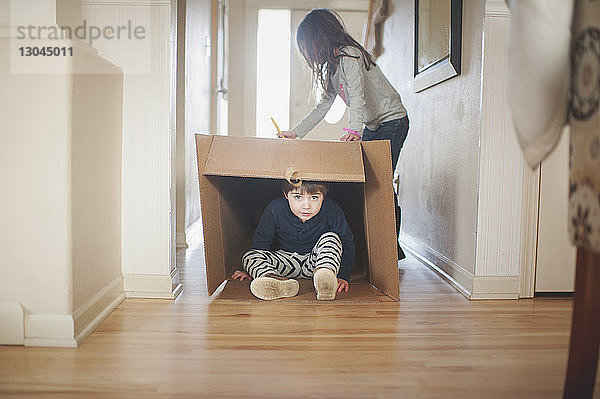 Porträt eines Jungen  der mit seiner Schwester zu Hause spielt