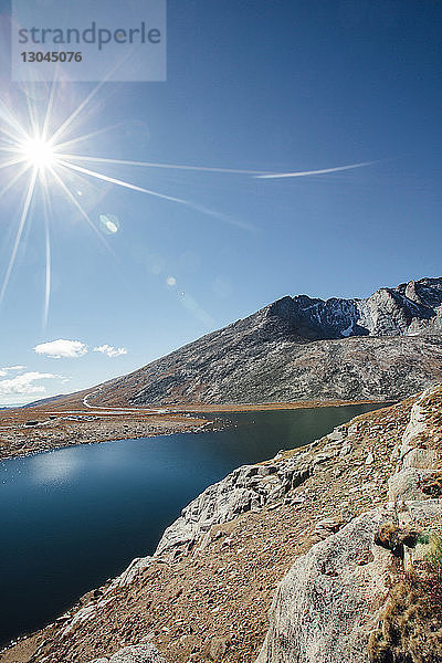Panoramablick auf einen felsigen Berg am See an einem sonnigen Tag
