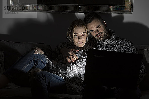 Ehepaar benutzt Laptop-Computer in der Dunkelkammer zu Hause