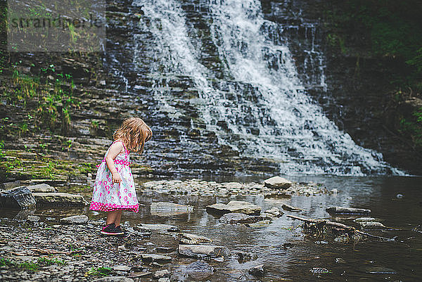 Seitenansicht eines Mädchens  das am Wasserfall steht