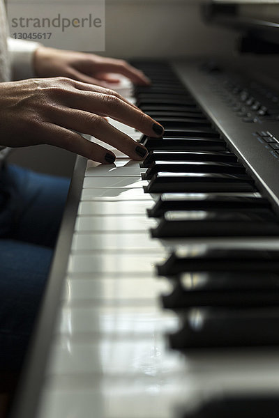 Beschnittene Hände eines Pianisten  der zu Hause Klavier übt