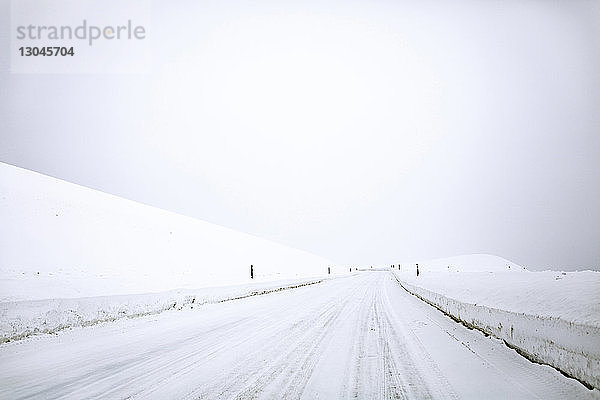 Schneebedeckte Straße gegen den Himmel