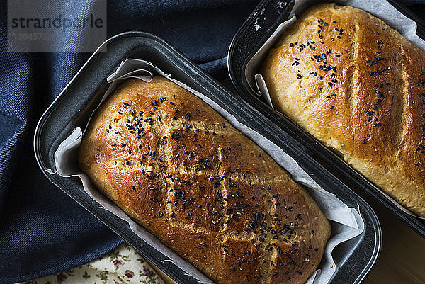 Draufsicht auf frisch gebackene Brote in Backblechen zu Hause