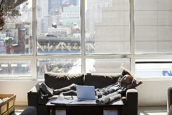 Geschäftsmann entspannt sich auf dem Sofa im Kreativbüro