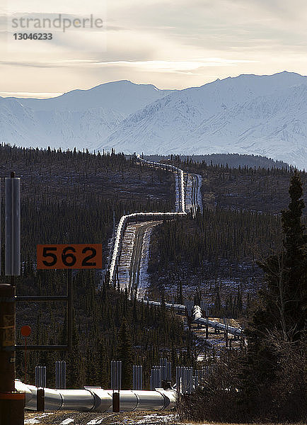 Trans-Alaska-Pipeline mitten im Wald gegen Berge im Winter