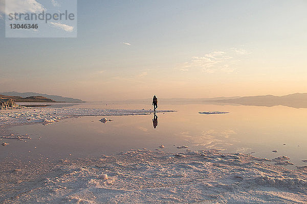 Mittelstrecke einer Frau  die bei Sonnenuntergang am Großen Salzsee steht