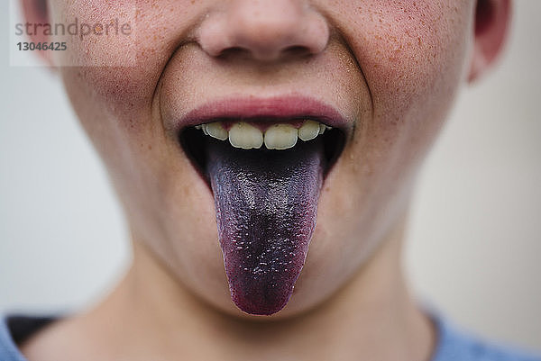Jungen mit violetter Zunge in der Mitte