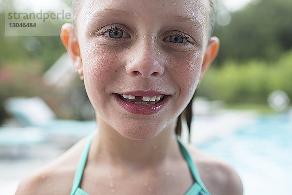 Nahaufnahme-Porträt eines nassen Mädchens gegen Schwimmbad