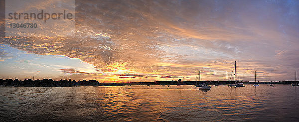 Panoramabild von Booten auf dem See vor dramatischem Himmel bei Sonnenuntergang