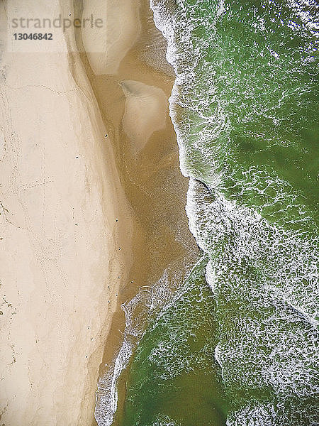 Draufsicht auf die Wellen  die am Strand an der Küste fließen