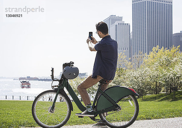 Seitenansicht eines Mannes  der in der Stadt auf dem Fahrrad sitzt