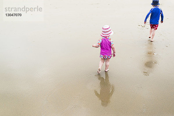 Hochwinkelansicht von Geschwistern beim Strandspaziergang