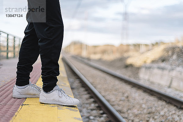 Niedriger Abschnitt eines Teenager-Mädchens am Bahnsteig des Bahnhofs