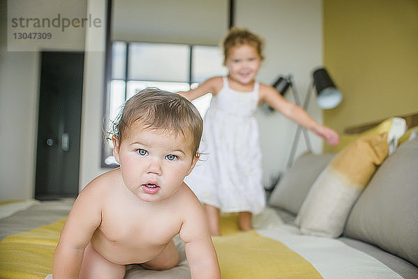 Porträt eines kleinen Jungen mit Schwester im Bett zu Hause