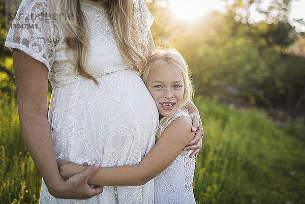 Mittelsektion einer schwangeren Mutter mit Tochter im Park