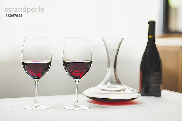 Nahaufnahme eines Rotweins mit Dekanter und Flasche auf dem Tisch