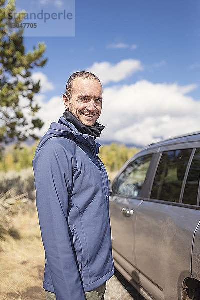 Porträt eines lächelnden Mannes  der im Grand-Teton-Nationalpark im Auto steht