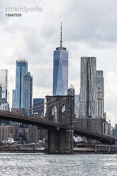 Brooklyn Bridge über den East River gegen moderne Gebäude