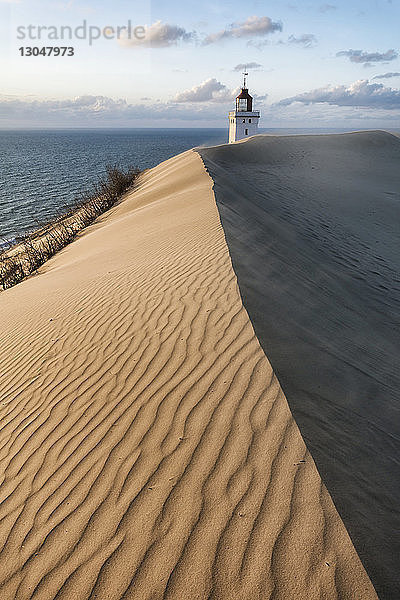 Leuchtturm am Sandstrand gegen den Himmel