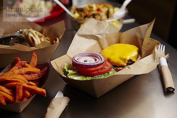 Hochwinkelansicht eines Burgers mit Pommes Frites auf dem Tisch