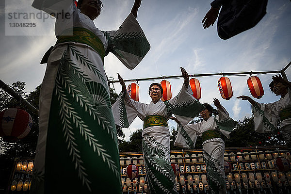 Niedrigwinkelaufnahme von tanzenden Frauen während des traditionellen Festes in Obon