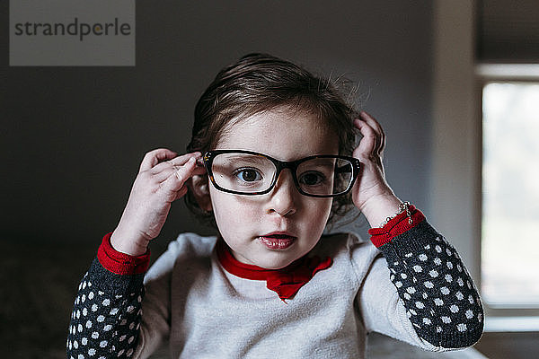 Porträt eines süßen Mädchens  das zu Hause eine Brille trägt