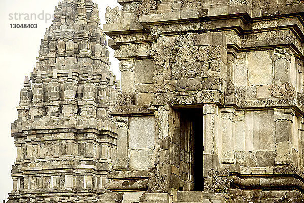Schnitzereien an den Wänden des Prambanan-Tempels vor klarem Himmel