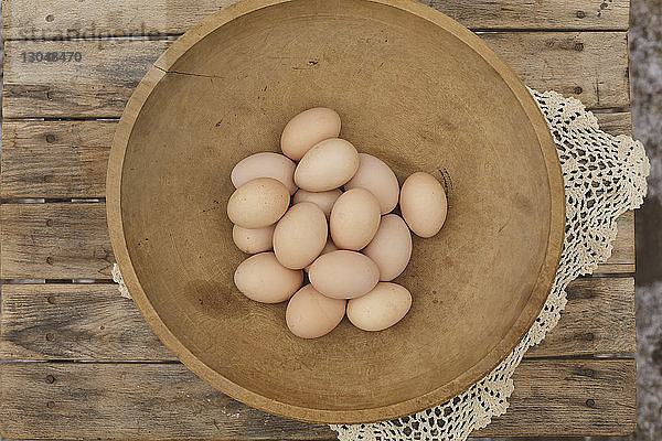 Hochwinkelansicht von Eiern in einer Holzschale auf dem Tisch