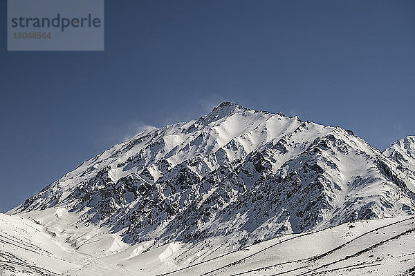 Schneebedeckter Berg vor strahlend blauem Himmel