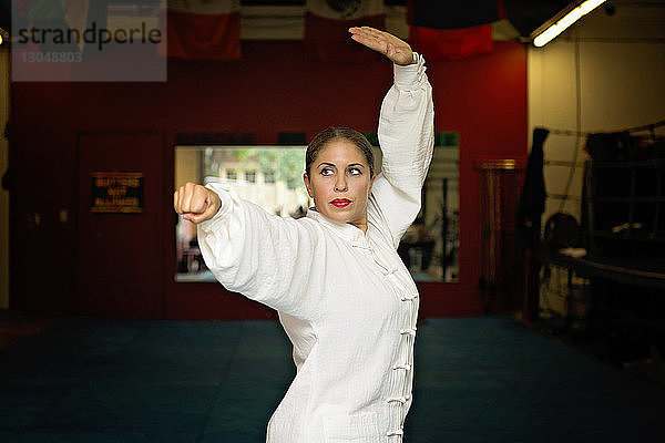 Frau übt Karate im Fitnessstudio