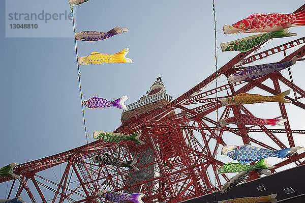 Niedrigwinkelansicht des Tokioter Turms vor klarem Himmel mit im Vordergrund hängenden Dekorationen