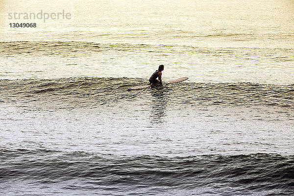 Hochwinkelaufnahme eines Mannes beim Surfen im Meer