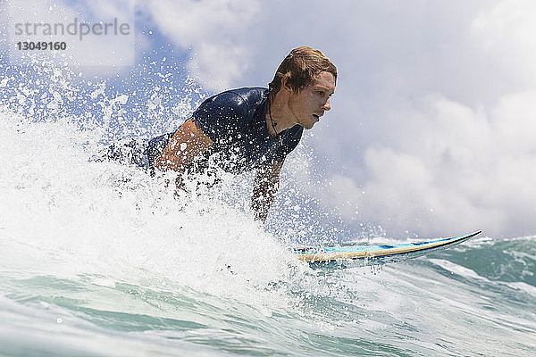 Seitenansicht eines Mannes beim Surfen im Meer