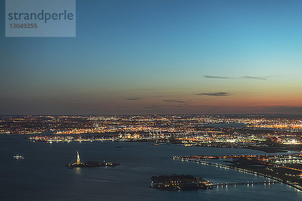 Luftaufnahme der beleuchteten Stadtlandschaft und des Hudson-Flusses gegen den Himmel in der Dämmerung