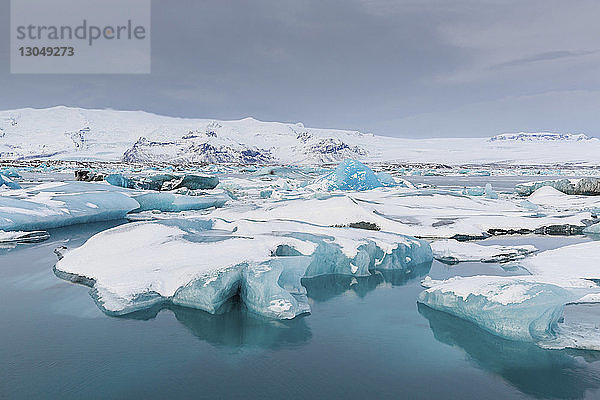 Eisberge im See gegen den Himmel im Winter