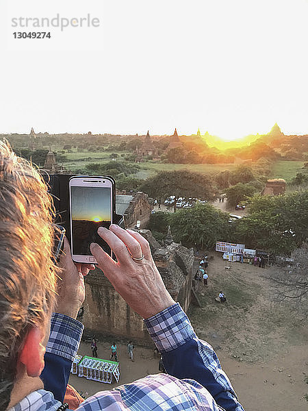 Frau fotografiert Tempel  während sie auf einem Berg vor klarem Himmel steht