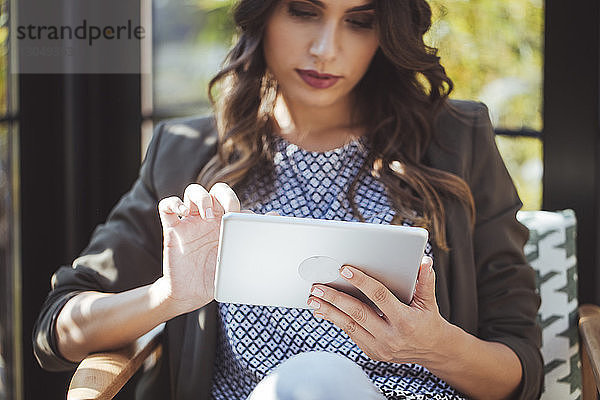 Frau benutzt Tablet-Computer im Café