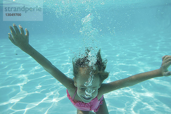 Mädchen schwimmt unter Wasser im Pool