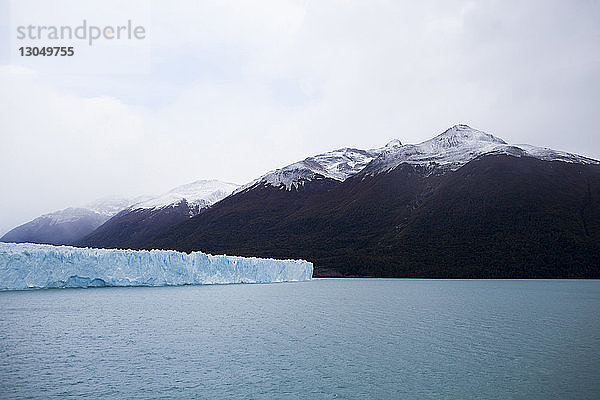 Landschaftliche Ansicht der Gletscher in See bei Berg gegen bewölkten Himmel