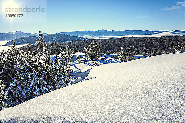 Szenenansicht eines schneebedeckten Berges vor blauem Himmel