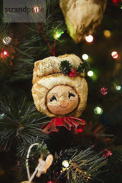 Nahaufnahme von Dekorationen  die am beleuchteten Weihnachtsbaum hängen