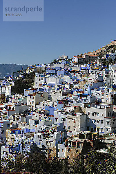 Blick auf die Stadtlandschaft am Berg vor klarem blauen Himmel