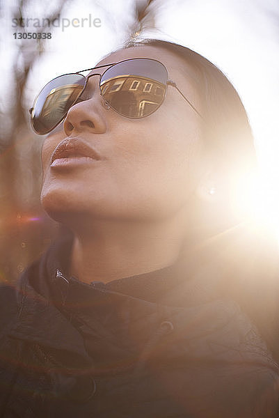 Nahaufnahme einer selbstbewussten Frau mit Sonnenbrille an einem sonnigen Tag