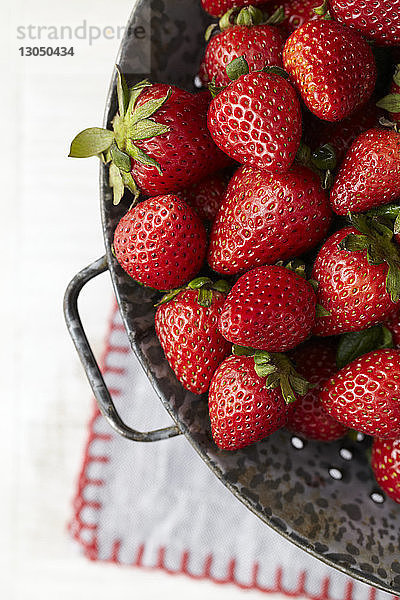 Draufsicht auf Erdbeeren im Sieb auf dem Tisch