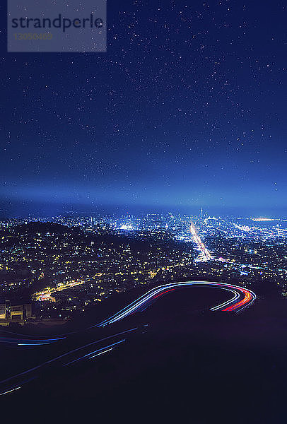 Majestätischer Anblick von Lichtspuren auf kurvenreicher Straße gegen ein Sternenfeld