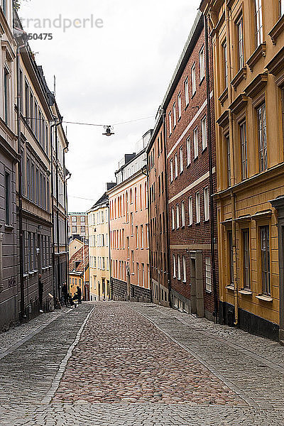 Kopfsteingepflasterter Fußweg inmitten von Gebäuden in der Stadt