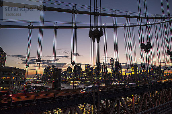Stadtlandschaft gegen den Himmel bei Sonnenuntergang durch die Manhattan-Brücke gesehen