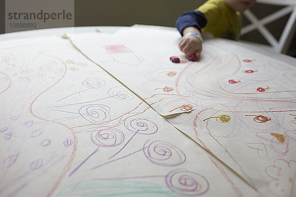 Mitschnitt eines Jungen  der zu Hause Kritzeleien auf Papier zeichnet