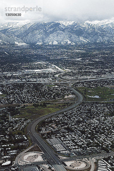 Luftaufnahme der Stadtlandschaft vor schneebedeckten Bergen