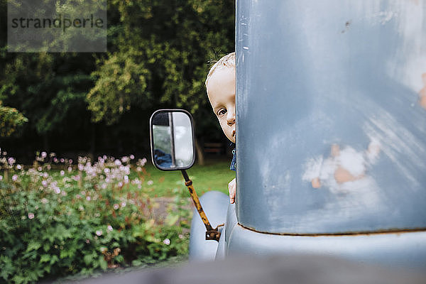 Junge schaut durch Oldtimer-Fenster